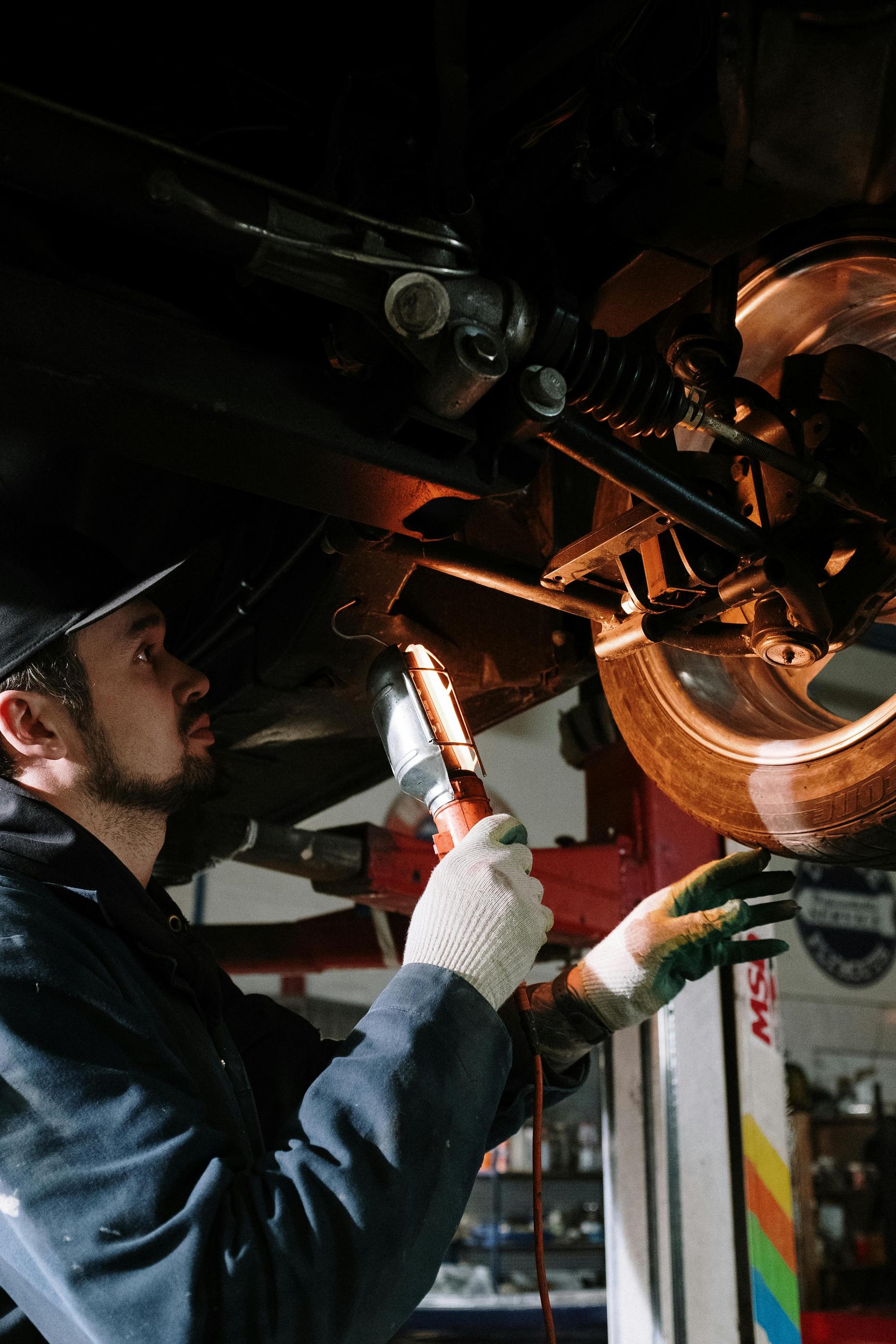 man working on car with flashlight